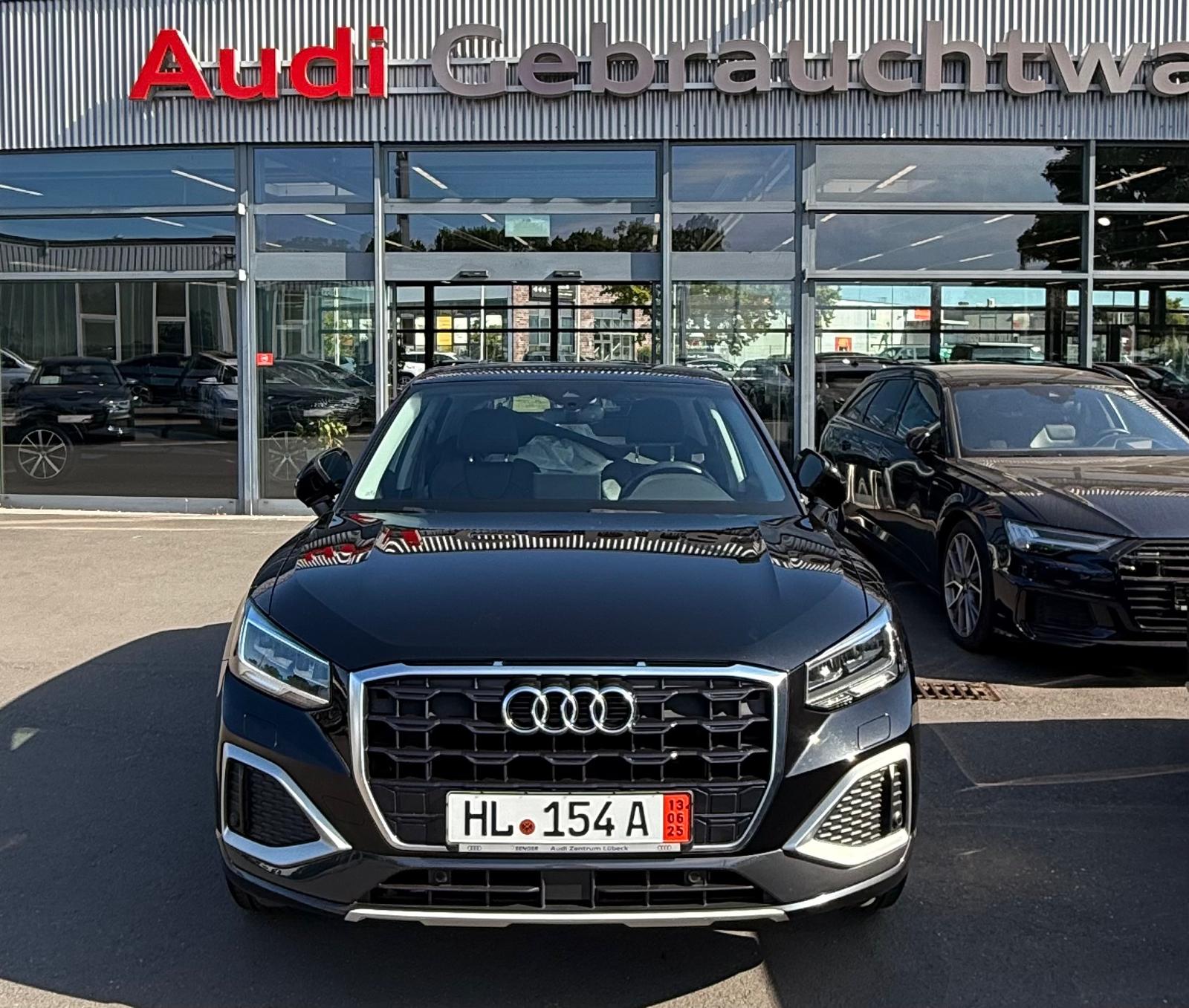 Audi Q2 35 TFSI nera del 2022 davanti a una concessionaria Audi
